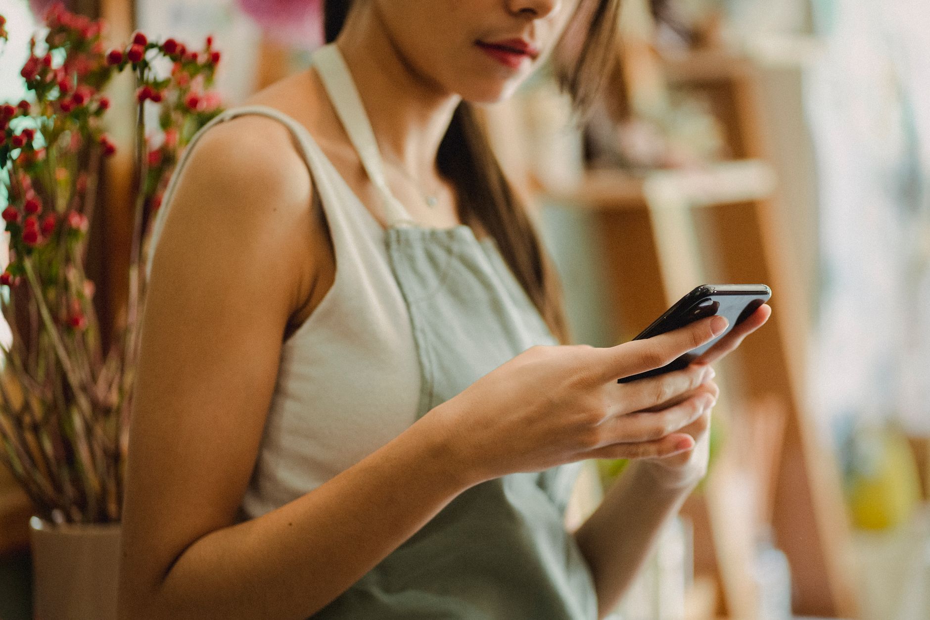 Propietaria de un comercio revisando en su móvil la visibilidad de su SEO local para pymes